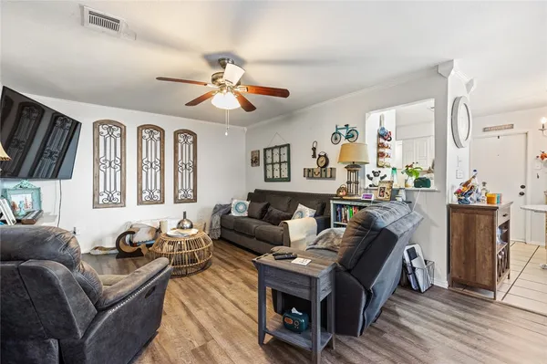 a living room with furniture a ceiling fan and a window