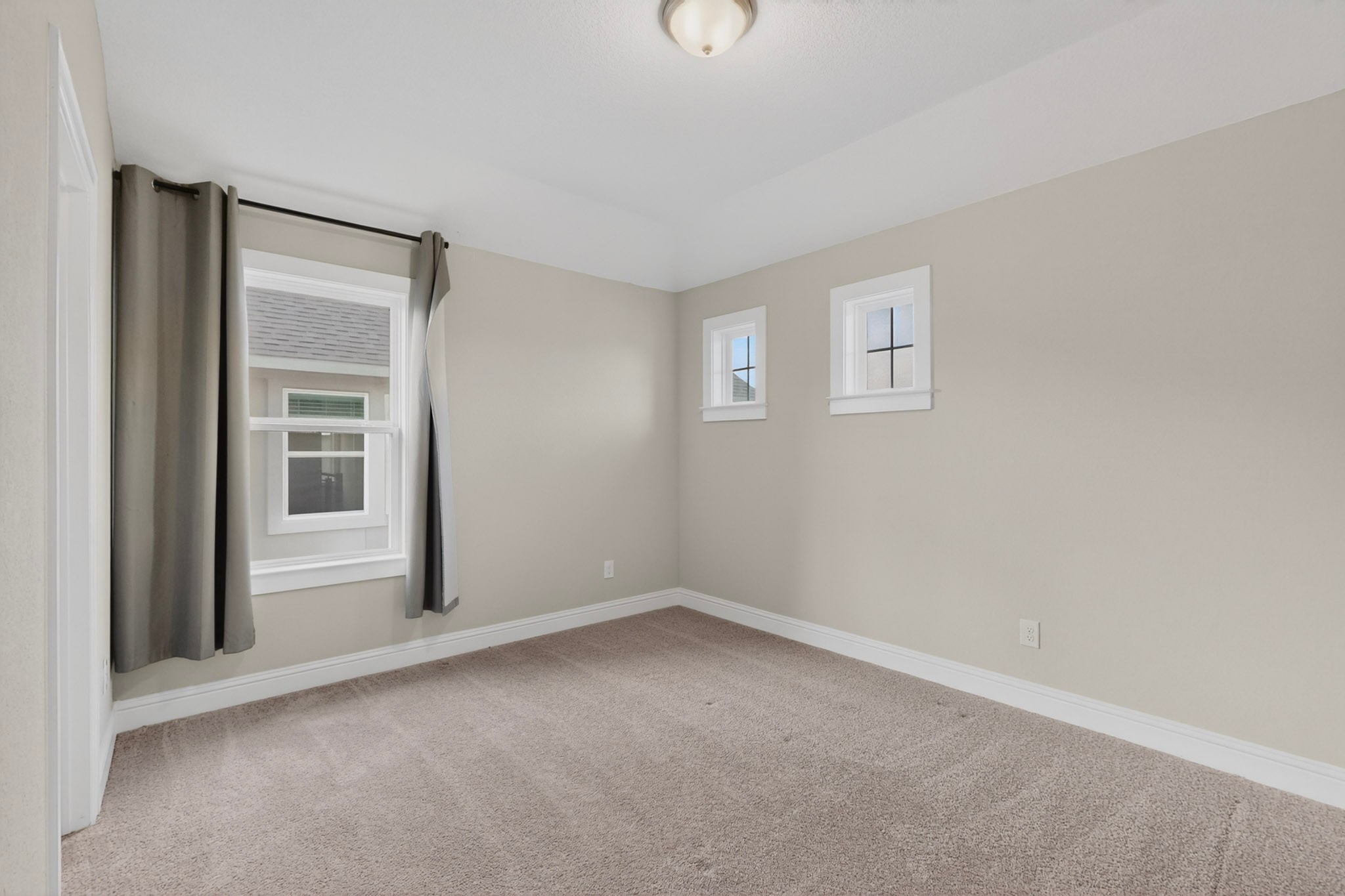 2605 Sam Bass Road, Unit 9 Round Rock, TX 78681 - Photo 33 of 38 A well-lit bedroom features plush carpet and multiple windows for abundant natural light.