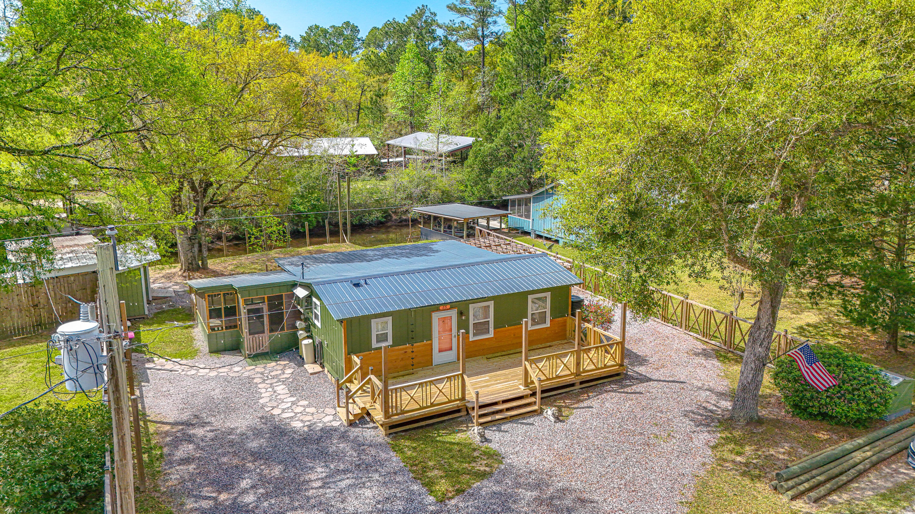 85 Our Street Vernon, FL 32462 - Photo 48 of 66 a yellow and blue house with a big yard and large trees