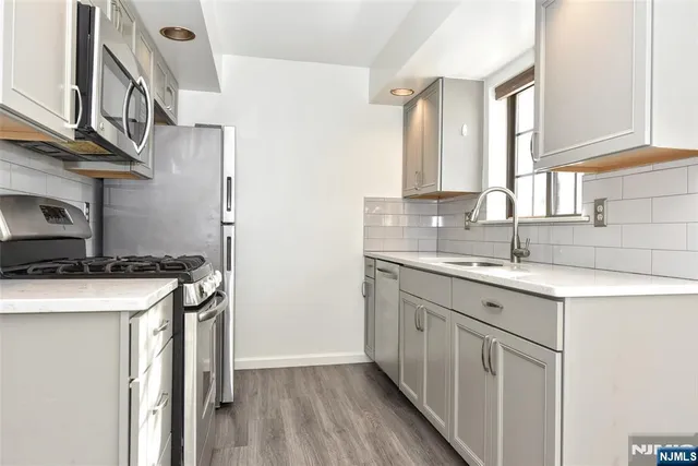 a kitchen with stainless steel appliances granite countertop a sink stove and cabinets