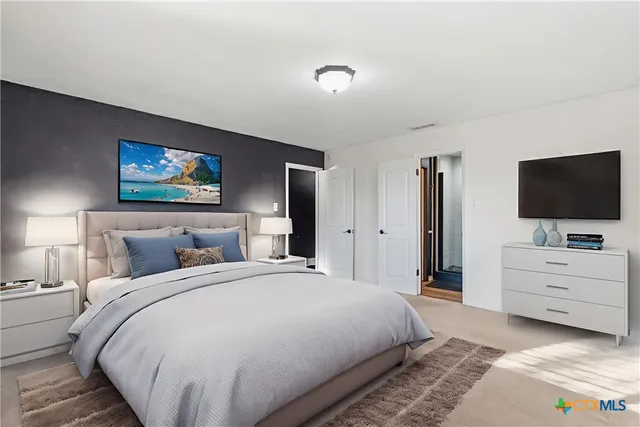 a bedroom with a bed and a flat screen tv