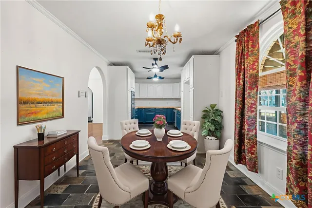 a view of a dining room with furniture a chandelier and wooden floor