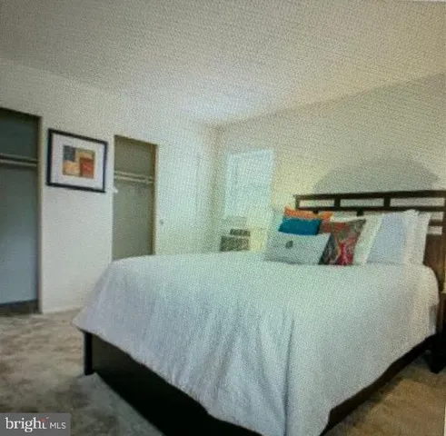 a bedroom with a bed and painting on the wall