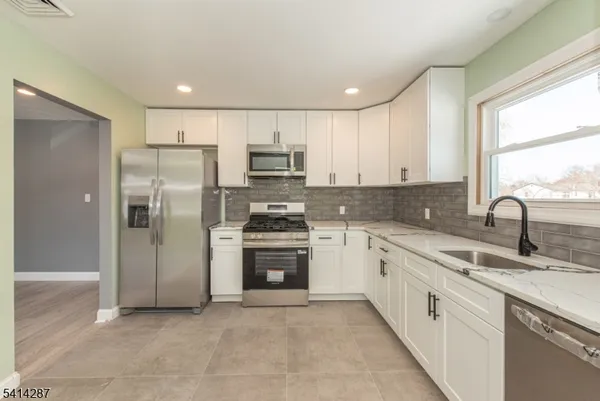 a kitchen with stainless steel appliances granite countertop a refrigerator and a sink