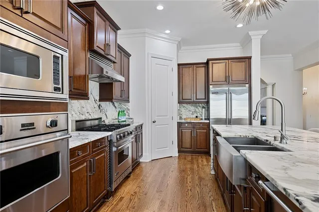 a kitchen with stainless steel appliances granite countertop a refrigerator and a stove