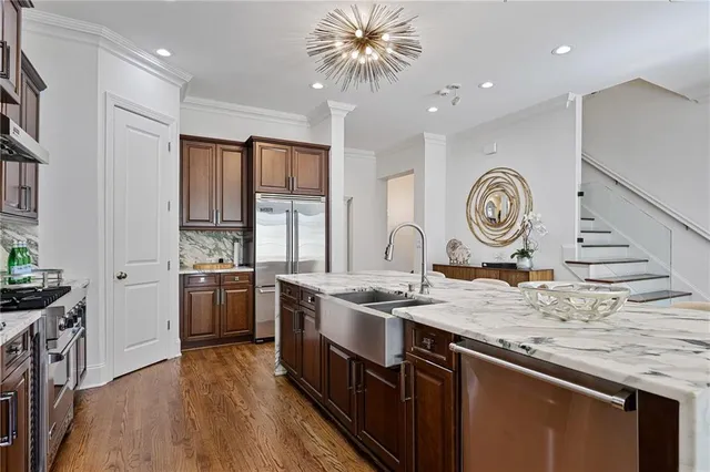 a bedroom with a large bed a chandelier and windows