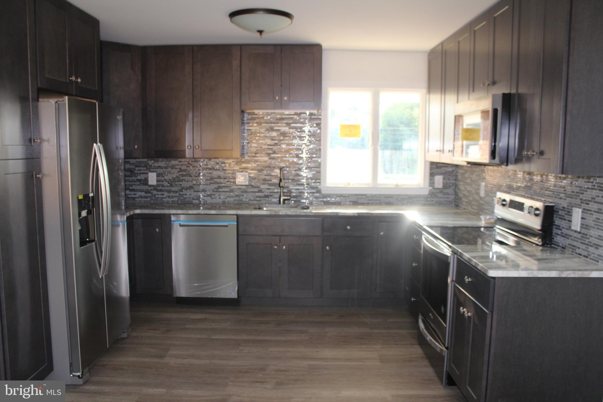 3128 Highway 206 Columbus, NJ 08022 - Photo 2 of 14 a kitchen with stainless steel appliances granite countertop a sink a stove a refrigerator and a microwave