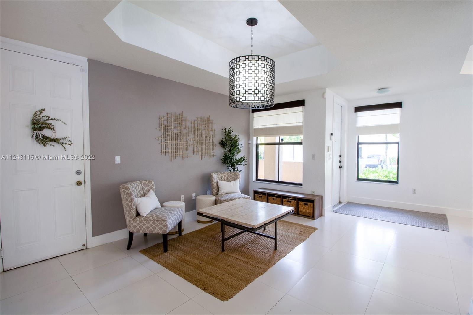 22737 Southwest 89th Path Cutler Bay, FL 33190 - Photo 16 of 27 a living room with dining table furniture and a chandelier