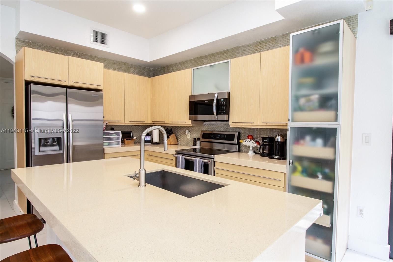 22737 Southwest 89th Path Cutler Bay, FL 33190 - Photo 18 of 27 a kitchen with stainless steel appliances a refrigerator a sink a stove and white cabinets with wooden floor