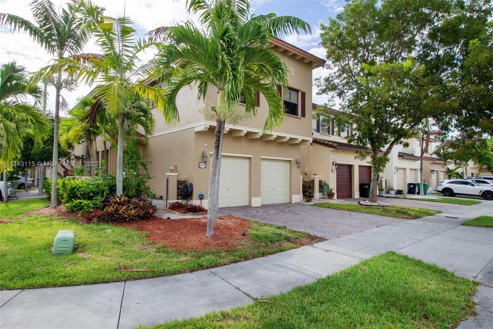22737 Southwest 89th Path Cutler Bay, FL 33190 - Photo 2 of 27 a front view of a house with a garden and trees