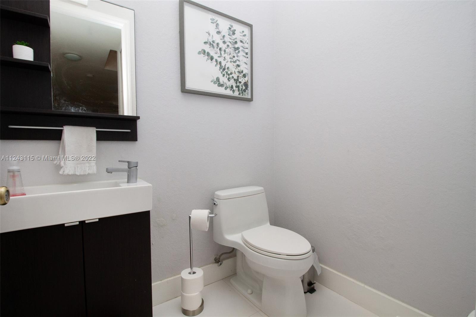 22737 Southwest 89th Path Cutler Bay, FL 33190 - Photo 23 of 27 a bathroom with a toilet a sink and mirror