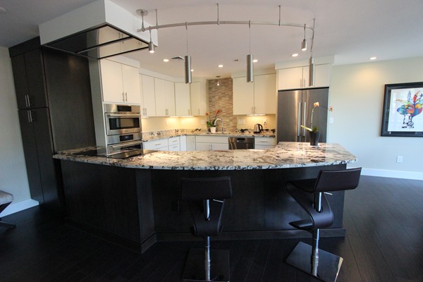 a kitchen with kitchen island granite countertop stainless steel appliances a sink stove and refrigerator