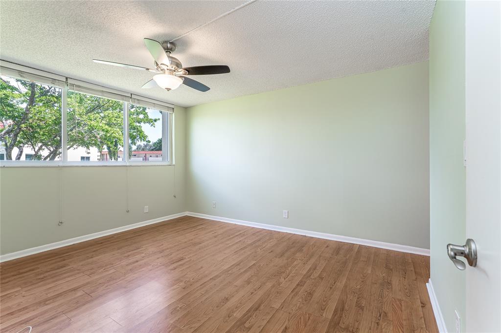 9720 South Hollybrook Lake Drive, Unit 205 Pembroke Pines, FL 33025 - Photo 13 of 57 an empty room with wooden floor fan and windows