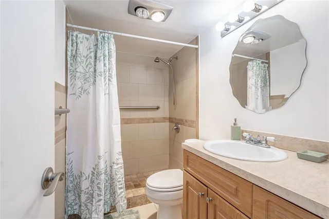 a bathroom with a granite countertop sink toilet and shower