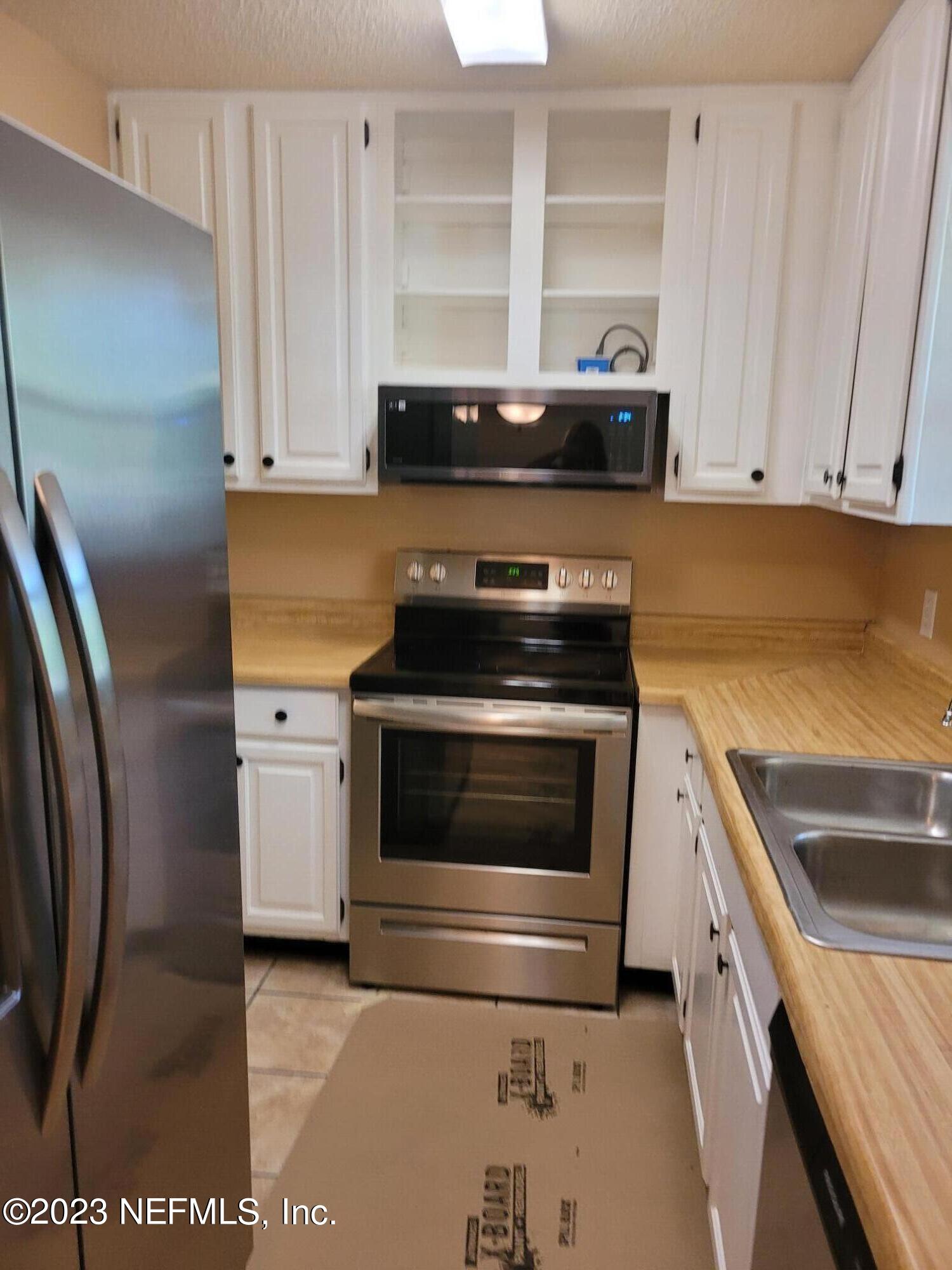 7925 Chateau Drive Jacksonville, FL 32221 - Photo 9 of 24 a kitchen with stainless steel appliances granite countertop a stove a microwave and a refrigerator