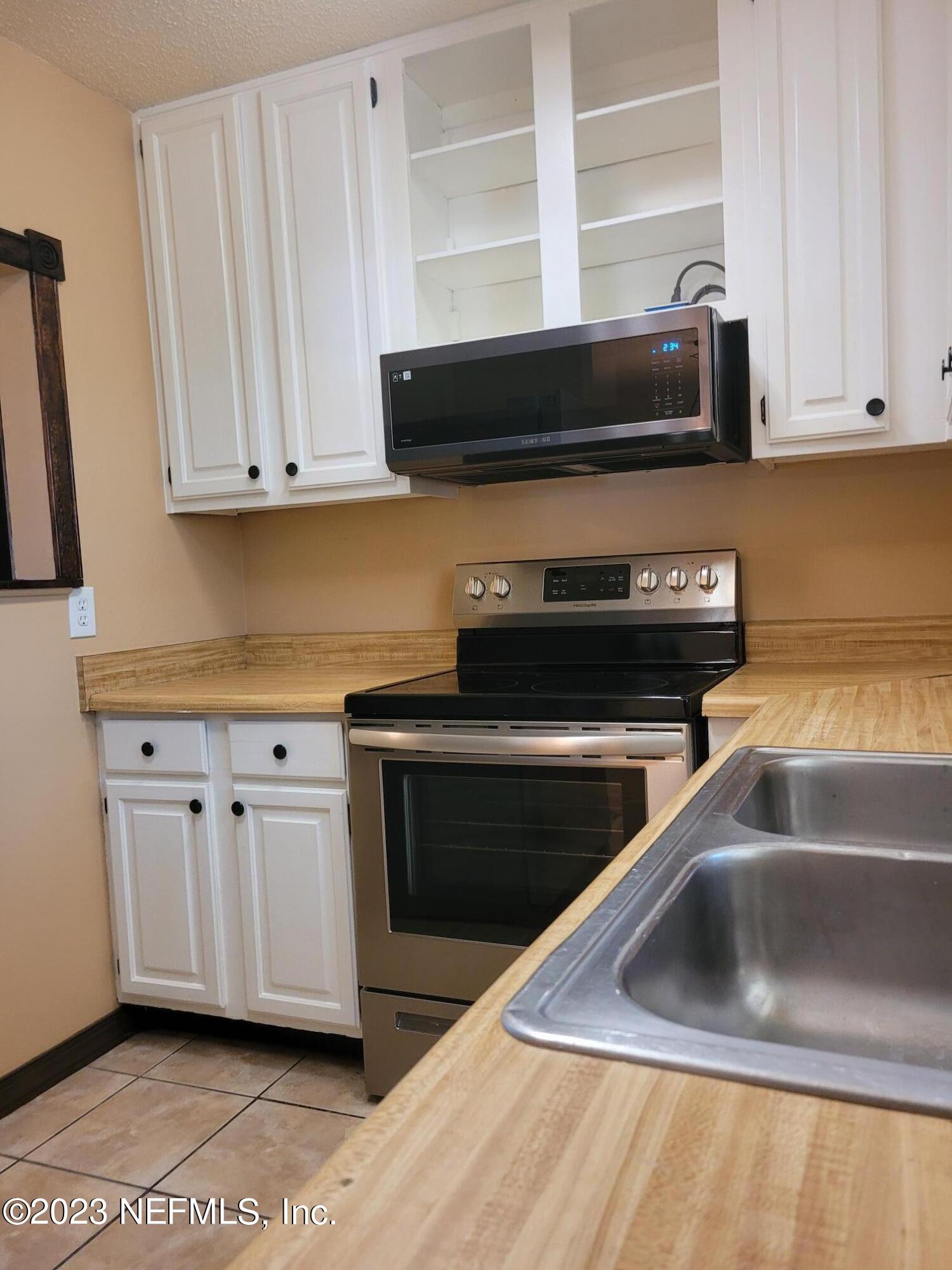 7925 Chateau Drive Jacksonville, FL 32221 - Photo 10 of 24 a kitchen with stainless steel appliances granite countertop a sink and a stove