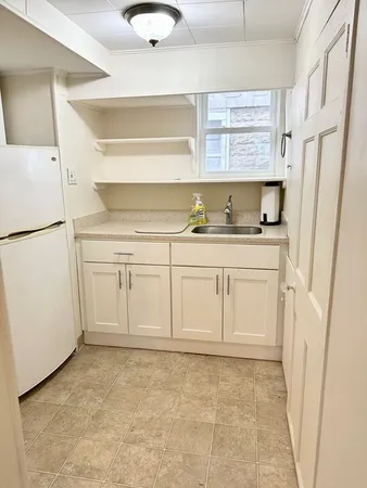 a kitchen with white cabinets and white appliances