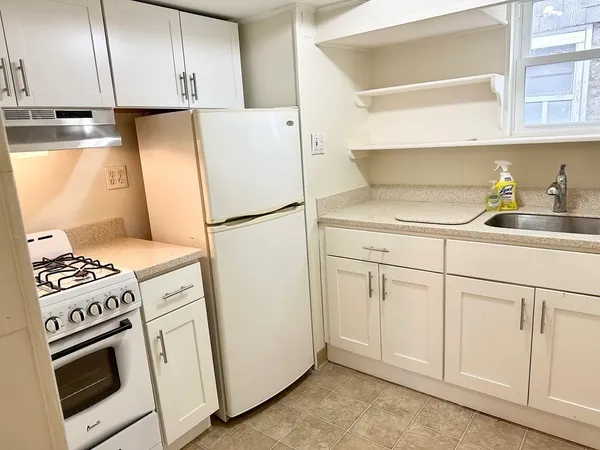 a kitchen with white cabinets and white appliances