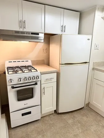 a white refrigerator freezer and a stove sitting inside of a kitchen