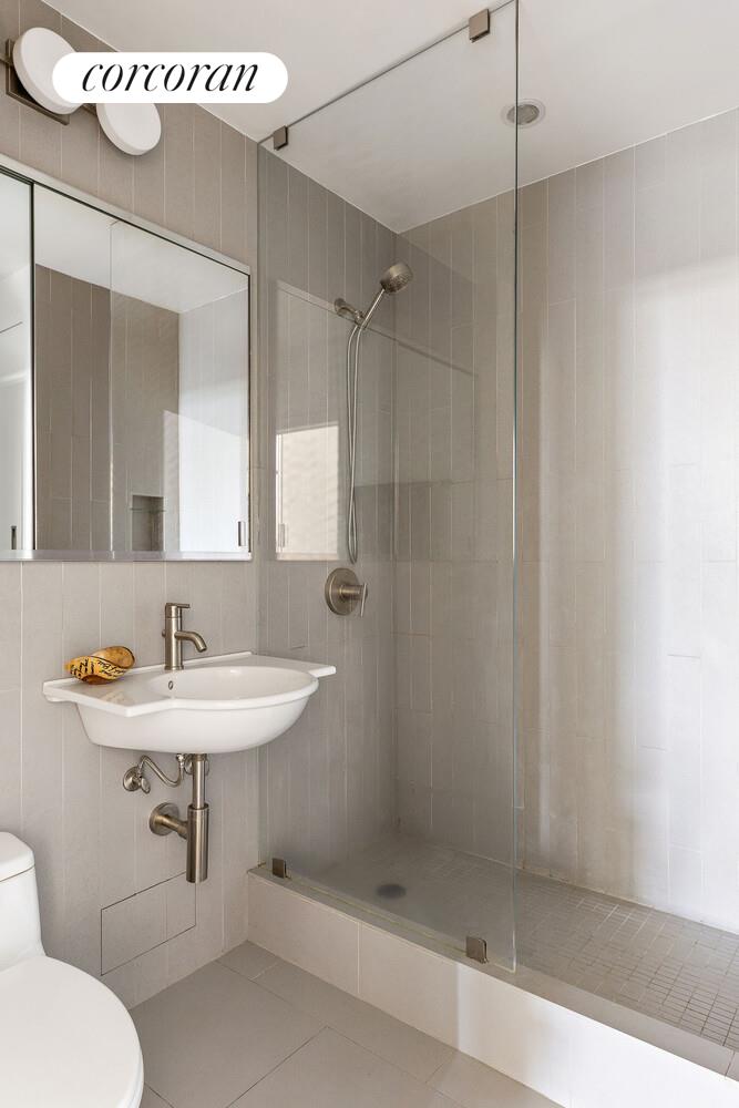 315 7th Avenue, Unit 4D Manhattan, NY 10001 - Photo 17 of 19 a bathroom with a sink a toilet and shower