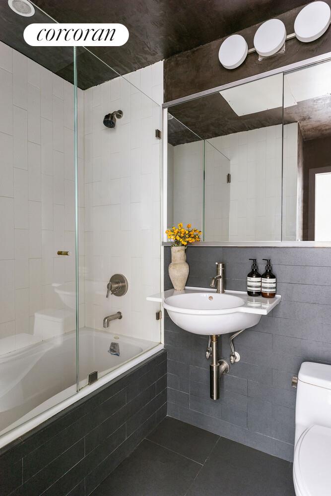 315 7th Avenue, Unit 4D Manhattan, NY 10001 - Photo 18 of 19 a bathroom with a sink a toilet and shower