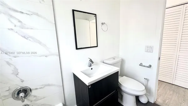 a bathroom with a toilet sink and mirror