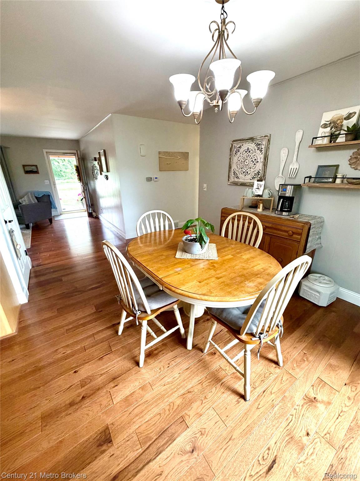 3259 North Seymour Road Flushing, MI 48433 - Photo 25 of 49 Dining area featuring wood-finish flooring, a decorative chandelier, and a built-in wall shelf