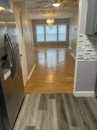 a view of an empty room with wooden floor