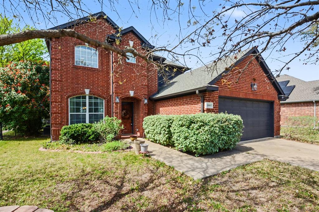 View of front of home with brick siding, driveway, a garage, and a front yard