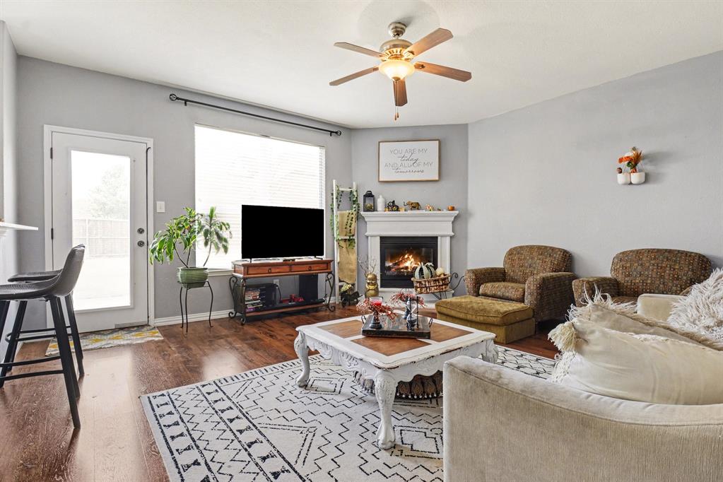 10005 Turrey Rowlett, TX 75089 - Photo 11 of 32 Living area with a ceiling fan, dark wood finished floors, and a glass covered fireplace