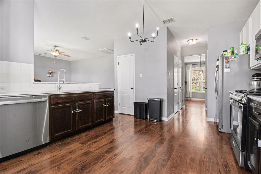 10005 Turrey Rowlett, TX 75089 - Photo 7 of 32 Kitchen with stainless steel appliances, ceiling fan, a chandelier, dark wood finished floors, and dark wood finish cabinetry