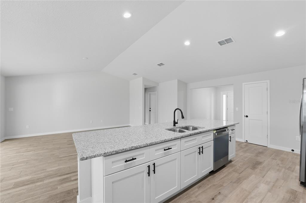 13161 Southwest 60th Avenue Ocala, FL 34473 - Photo 15 of 36 a kitchen with a sink dishwasher and white cabinets with wooden floor