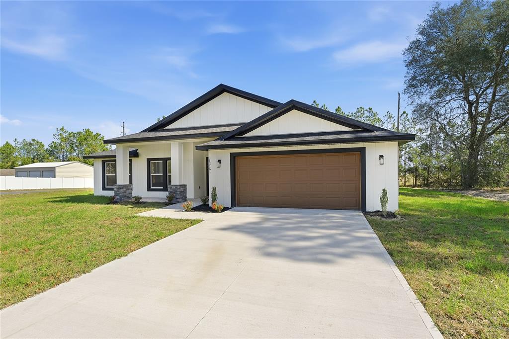 13161 Southwest 60th Avenue Ocala, FL 34473 - Photo 2 of 36 a front view of a house with a garden and yard