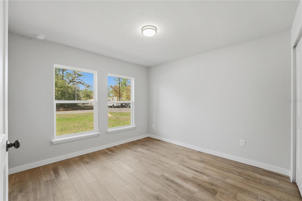 13161 Southwest 60th Avenue Ocala, FL 34473 - Photo 27 of 36 an empty room with wooden floor and windows
