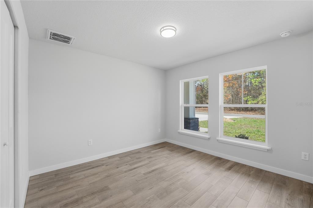 13161 Southwest 60th Avenue Ocala, FL 34473 - Photo 29 of 36 an empty room with wooden floor and windows