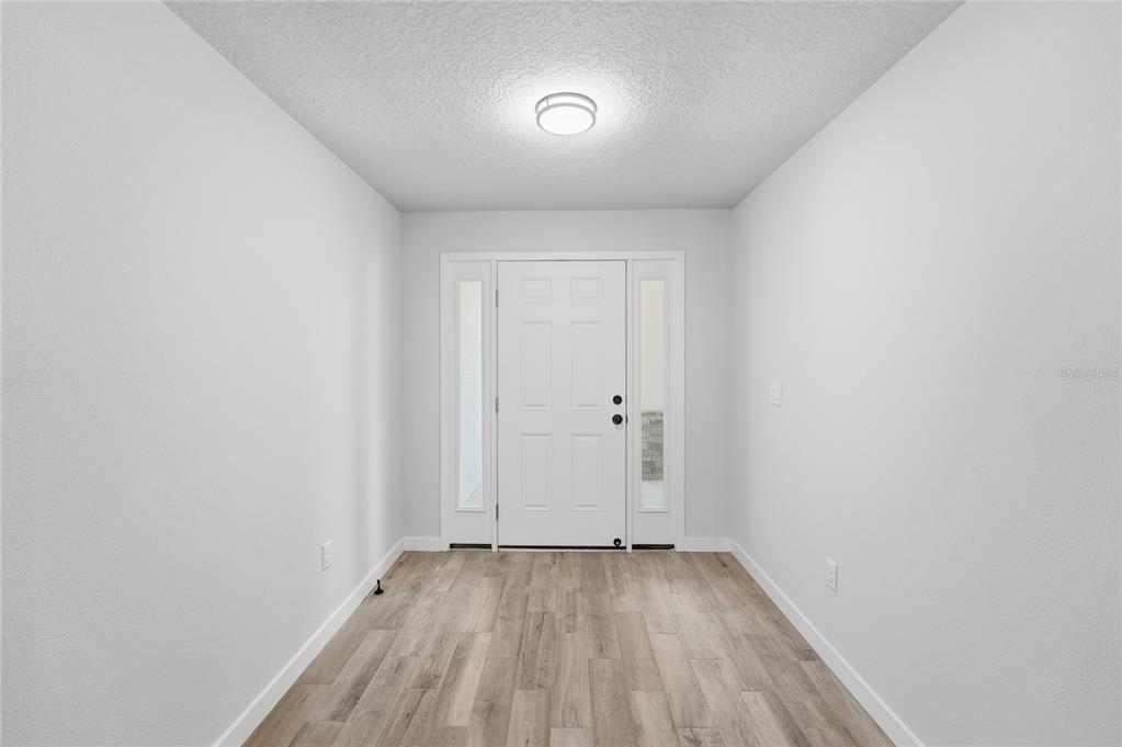 13161 Southwest 60th Avenue Ocala, FL 34473 - Photo 5 of 36 a view of a room with wooden floor and white walls