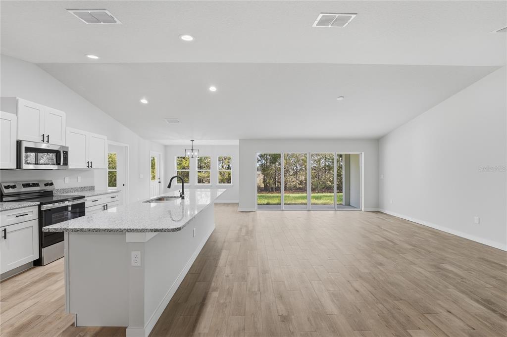 13161 Southwest 60th Avenue Ocala, FL 34473 - Photo 6 of 36 a kitchen with stainless steel appliances granite countertop a stove a sink and a refrigerator