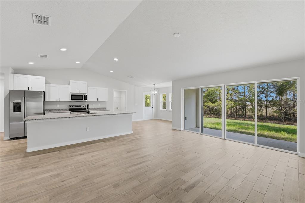 13161 Southwest 60th Avenue Ocala, FL 34473 - Photo 7 of 36 a view of kitchen with kitchen island stainless steel appliances wooden floor and window