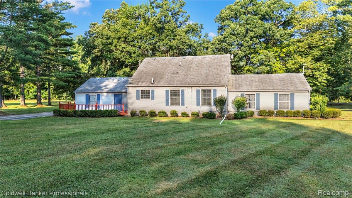 980 West Predmore Road Oakland, MI 48363 - Photo 3 of 11 Ranch-style residence featuring a light-colored exterior with blue window shutters and a gray shingled roof