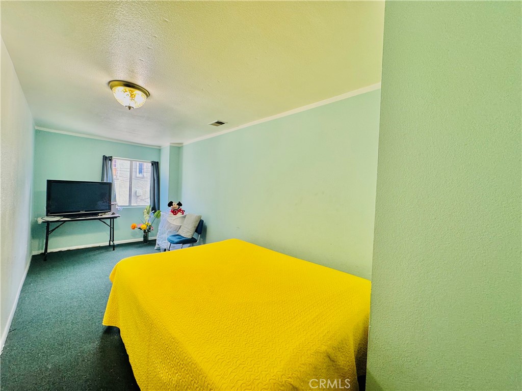812 East 8th Street Long Beach, CA 90813 - Photo 32 of 40 a bedroom with a bed and a flat screen tv