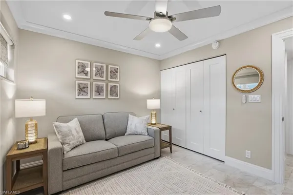 a living room with furniture a clock and a ceiling fan