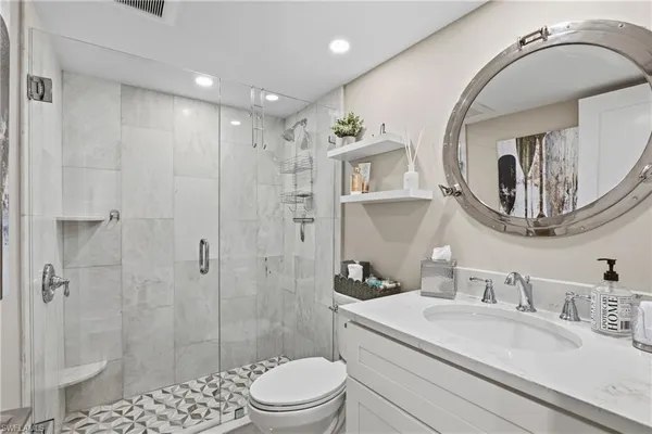 a bathroom with a sink a toilet and shower