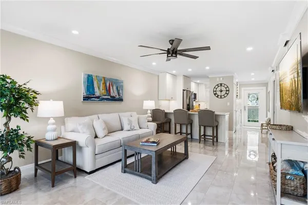 a living room with furniture kitchen view and a potted plant