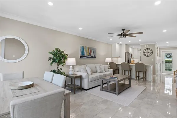 a living room with furniture a mirror and a potted plant