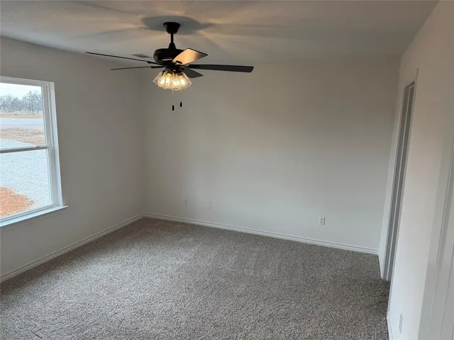 a view of empty room with ceiling fan