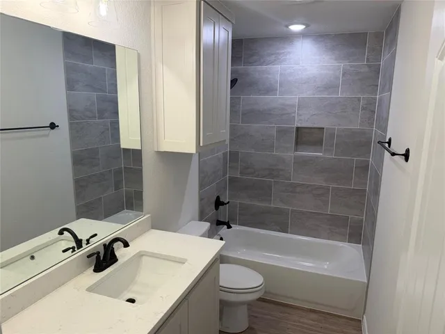 a bathroom with a sink mirror toilet and bathtub