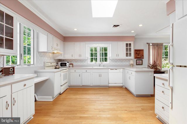 a kitchen with white cabinets and white appliances