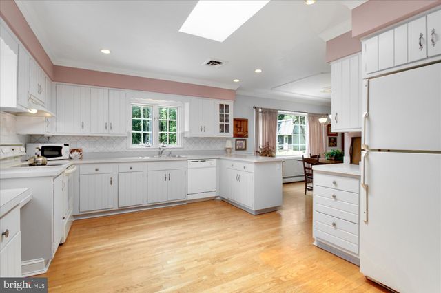 a kitchen with white cabinets and white appliances
