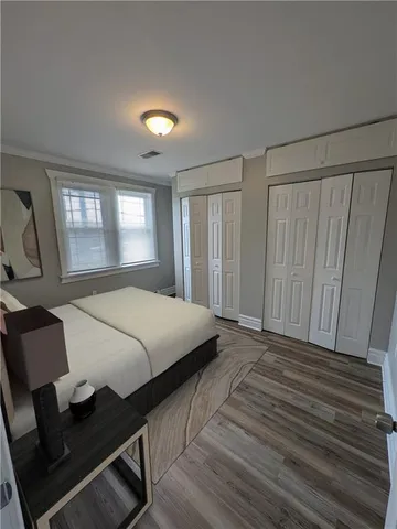 a bed sitting in a spacious bedroom next to a window