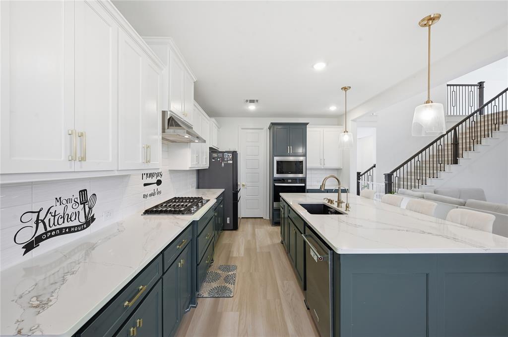 2188 Cloverfern Way Haslet, TX 76052 - Photo 5 of 30 a kitchen with stainless steel appliances granite countertop sink stove and refrigerator